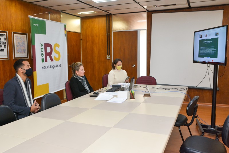 Imagem da sala, com os participantes assistindo a apresentação virtual.