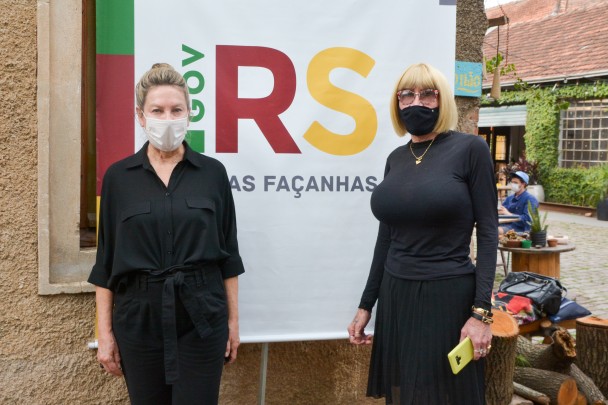 Secretária Regina Becker e presidenta da Igualdade RS, Marcelly Malta posando com o logo novas façanhas