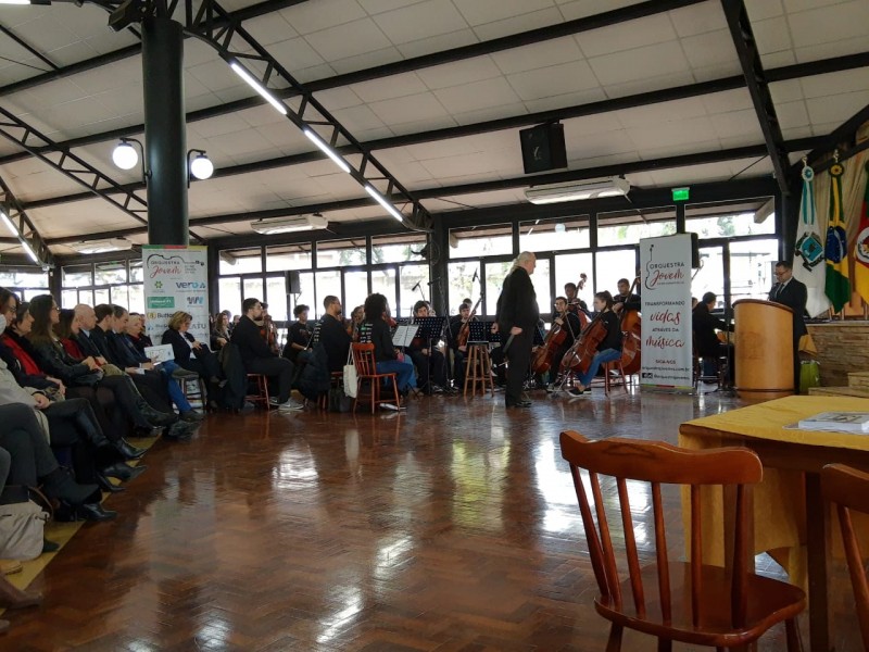 músicos sentados com maestro