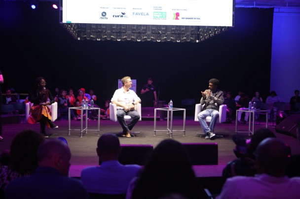 foto colorida do ator Hélio de La Peña falando no palco