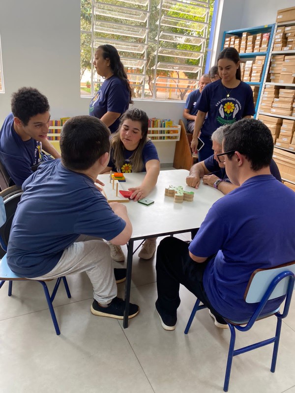 grupo de alunos em volta da mesa com atividades